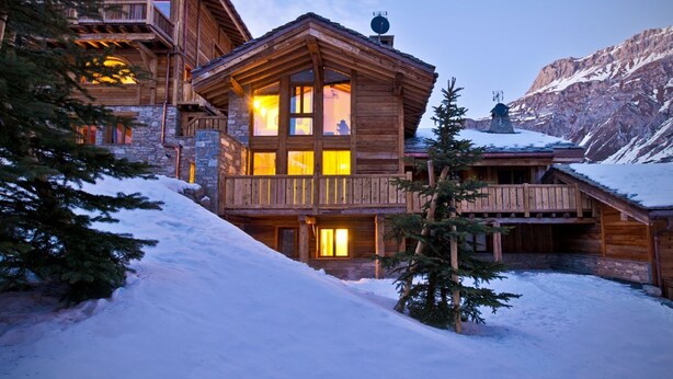 A wooden lodge with multiple balconies, stone walls, and a snowy landscape. - Chalet Genepy by Interhome (Peisey-Nancroix)