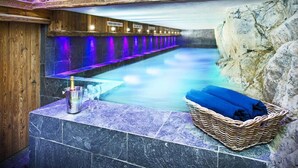 A spa area with a stone pool, wooden walls, and a stone bench with a basket. - Chalet Genepy by Interhome (Peisey-Nancroix)