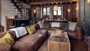 A rustic interior with a leather sofa, wooden coffee table, and a bar area. - Chalet Genepy by Interhome (Peisey-Nancroix)