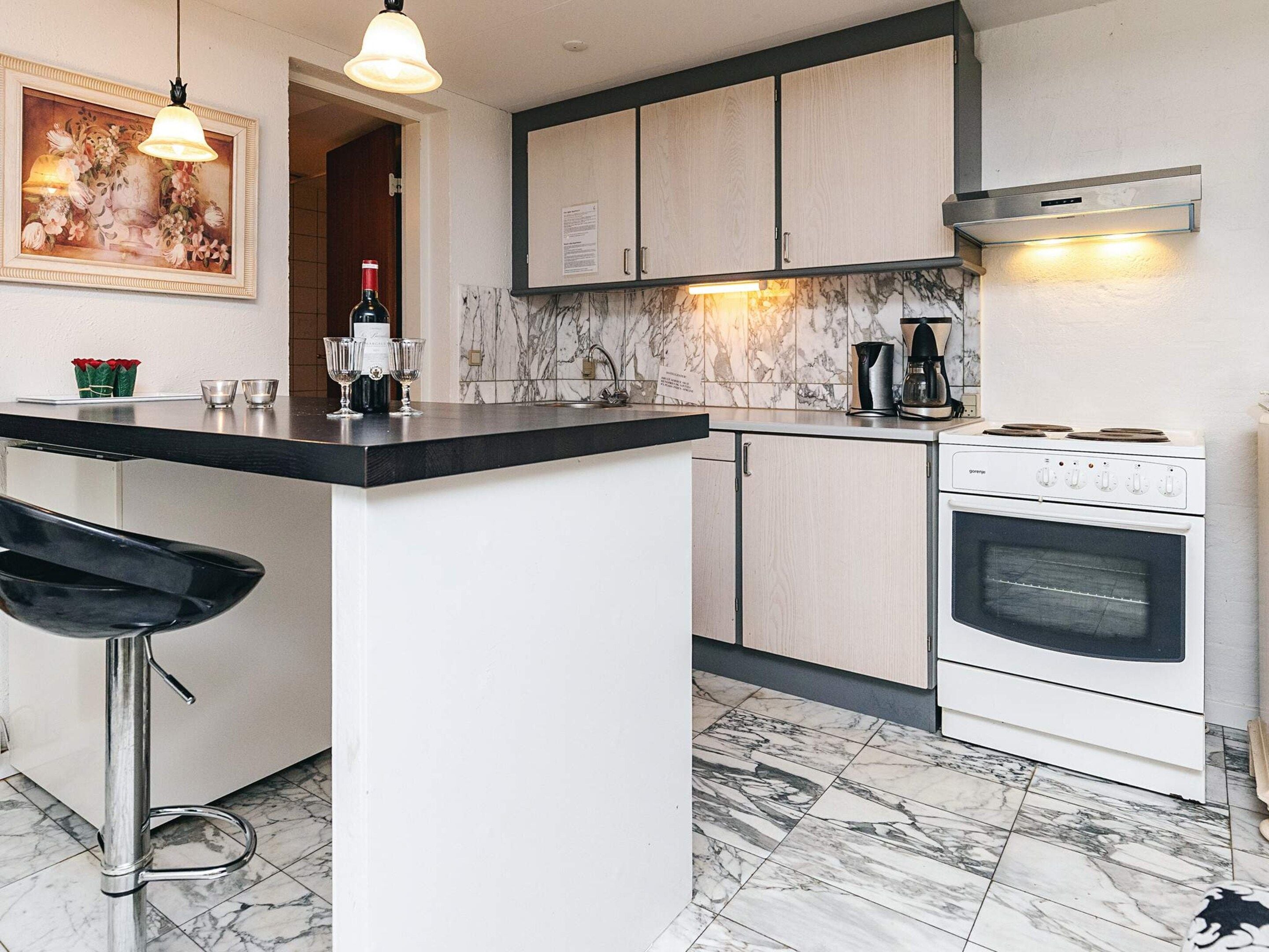 Una cocina con una isla central, estufa y cafetera.