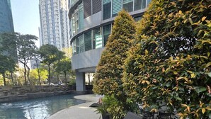 Un'area esterna moderna con sedute relax, un elemento d'acqua e un edificio con ampie vetrate sullo sfondo.