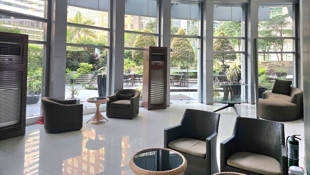 Un'ampia hall con ampie finestre, arredamento moderno e vista sulla città.