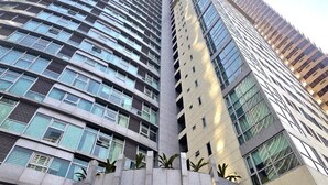Un edificio di grandi dimensioni con facciata curvilinea, ampie finestre e un design architettonico moderno.