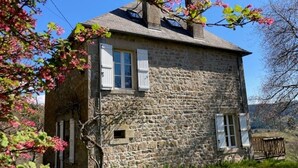 A stone building with two windows and a chimney. - Relaxation and space in a family home with breathtaking views! (Ambrugeat)