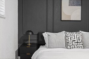 A bedroom with a bed, a nightstand, a lamp, and a wall-mounted artwork. - Prime Location - Cozy Luxury Suite With Free Parking and Crib in South Tampa!! (Tampa)