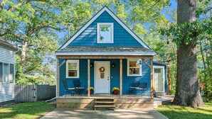 A blue house with a front porch, a door, and a small window. - Dogs Stay Free! Lakefront Home near Notre Dame (South Bend)