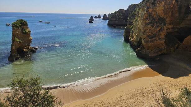 A coastal landscape with clear blue water, sandy beach, and rocky formations. - BOAVISTA GOLF RESORT - apartment with large terrace overlooking the GREEN (LAGOS)