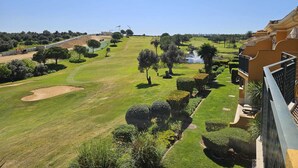 A golf course with a water feature, well-maintained lawns, and a building with balconies. - BOAVISTA GOLF RESORT - apartment with large terrace overlooking the GREEN (LAGOS)