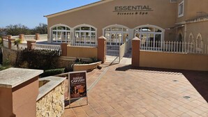 A building with a sign reading 'ESSENTIAL Fitness & Spa' and a poster advertising 'Sunday Carvery.' - BOAVISTA GOLF RESORT - apartment with large terrace overlooking the GREEN (LAGOS)
