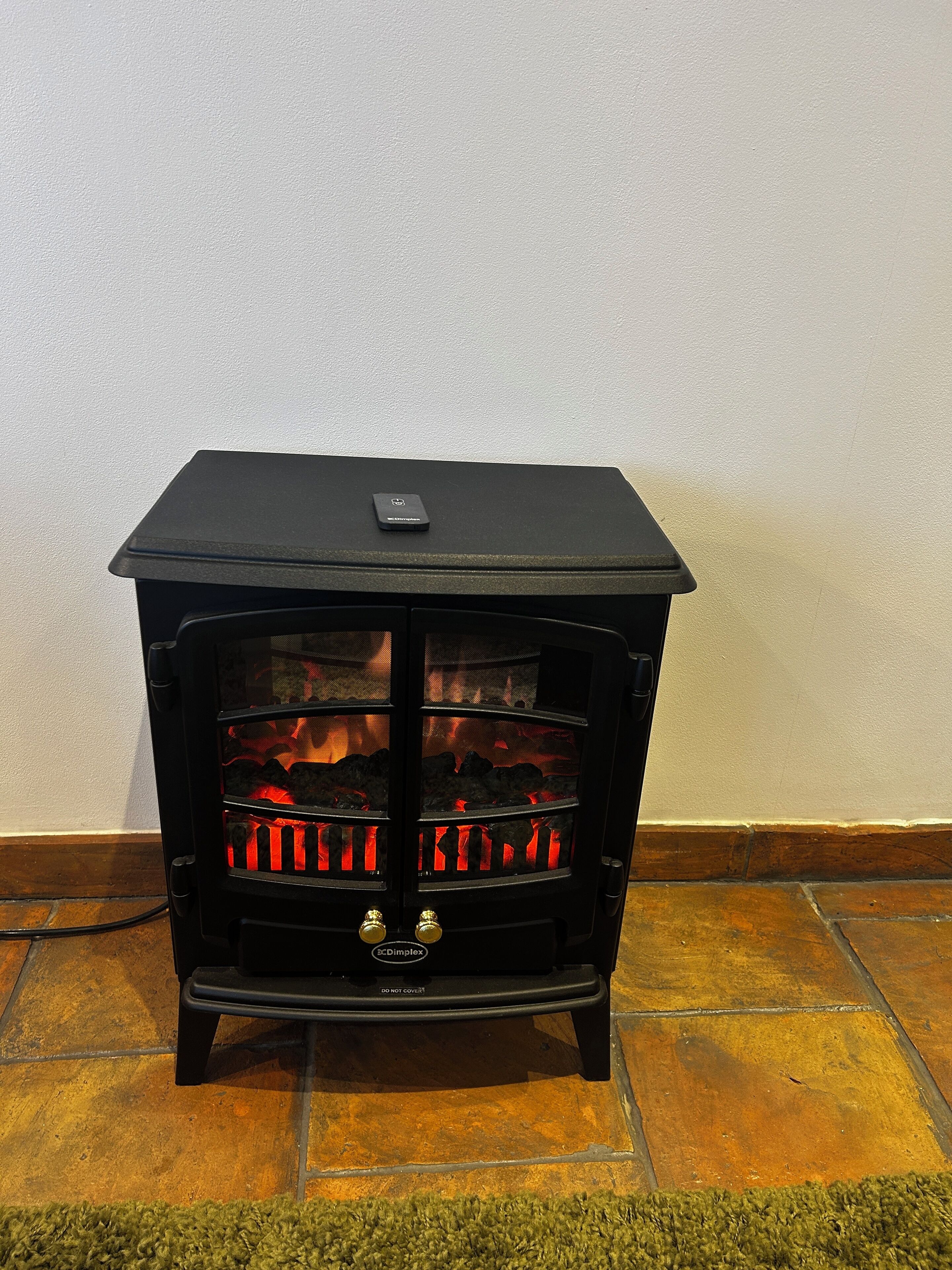 A black wood-burning stove with glass doors, a control panel, and a digital display.