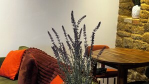 A living room with a green sofa, a wooden table, and a potted plant. - The Little House Annex – A Peaceful Countryside Stay in Beautiful Shotteswell. (Shotteswell)