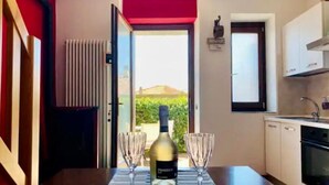Un coin repas avec une table dressée pour deux personnes, une bouteille de vin et deux verres.