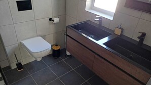 Un baño con inodoro, lavabo y ventana.