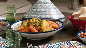 A traditional Moroccan tagine dish with vegetables, a teapot, and bread on a table. - Majorelle room (Tours)