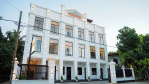 Um edifício branco de vários andares com uma placa no topo que diz 'AUHUNU'.