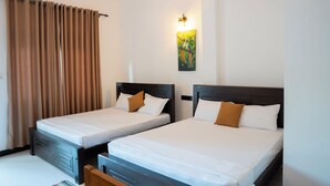 Quarto de hotel com duas camas, um quadro na parede e uma cortina.