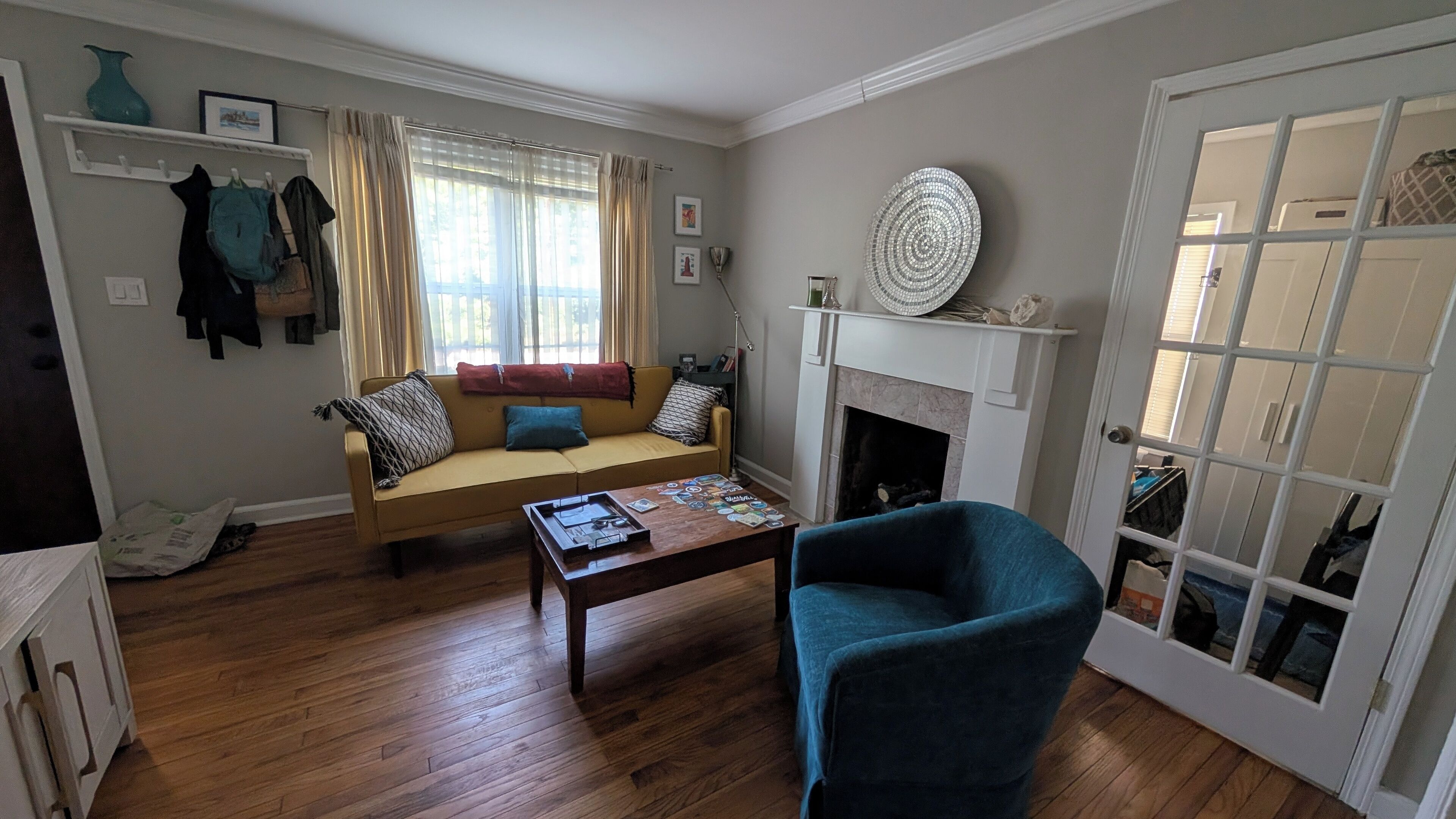 Ein Wohnzimmer mit einer Couch, einem Couchtisch, einem Kamin und einer Glastür.