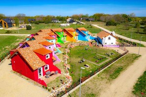 A residential area with colorful houses, a playground, and a dirt road. - Mexican-themed Holiday Homes (Ustka)