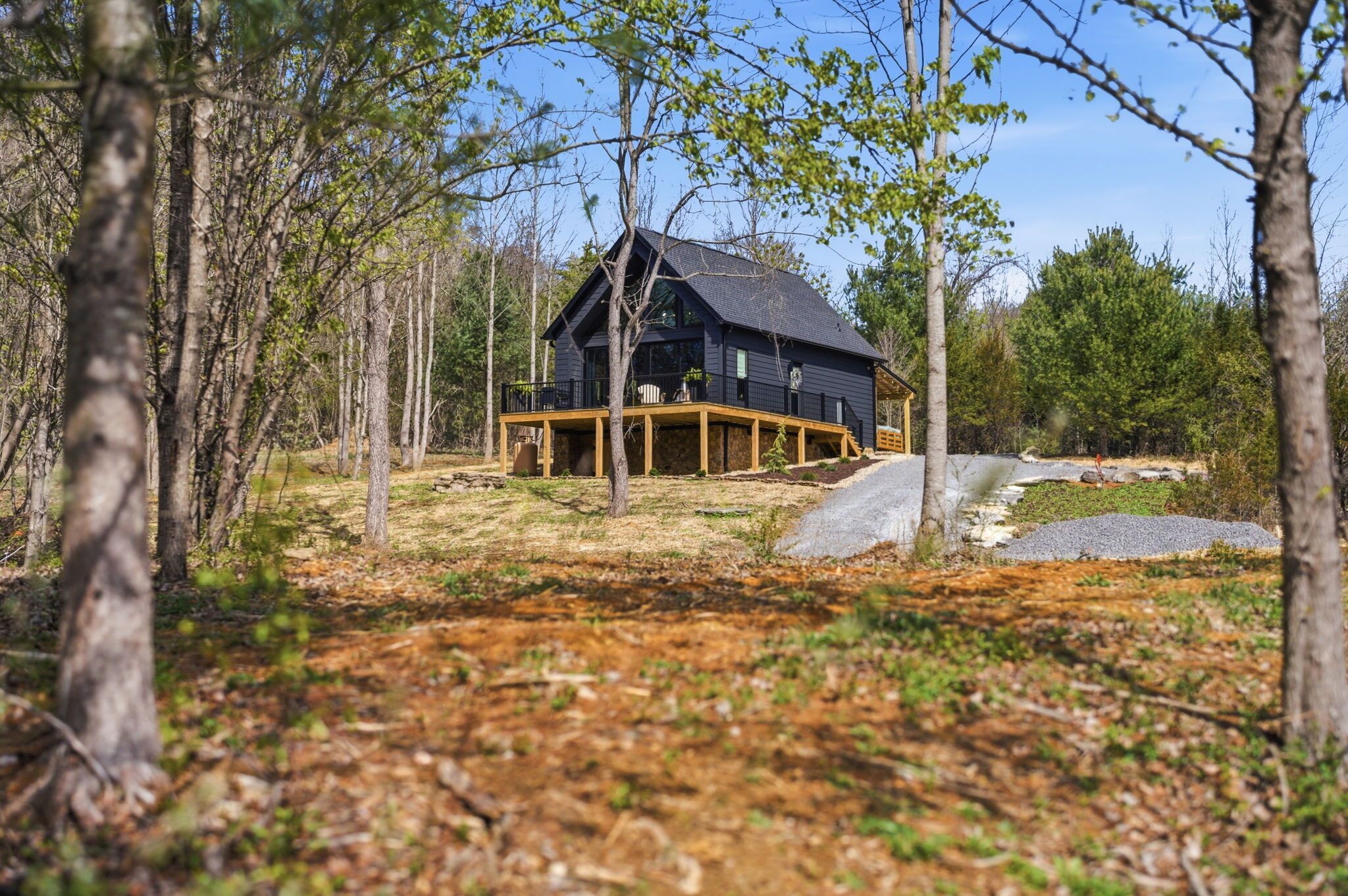 Une cabane dotée d’une terrasse, entourée d’arbres.