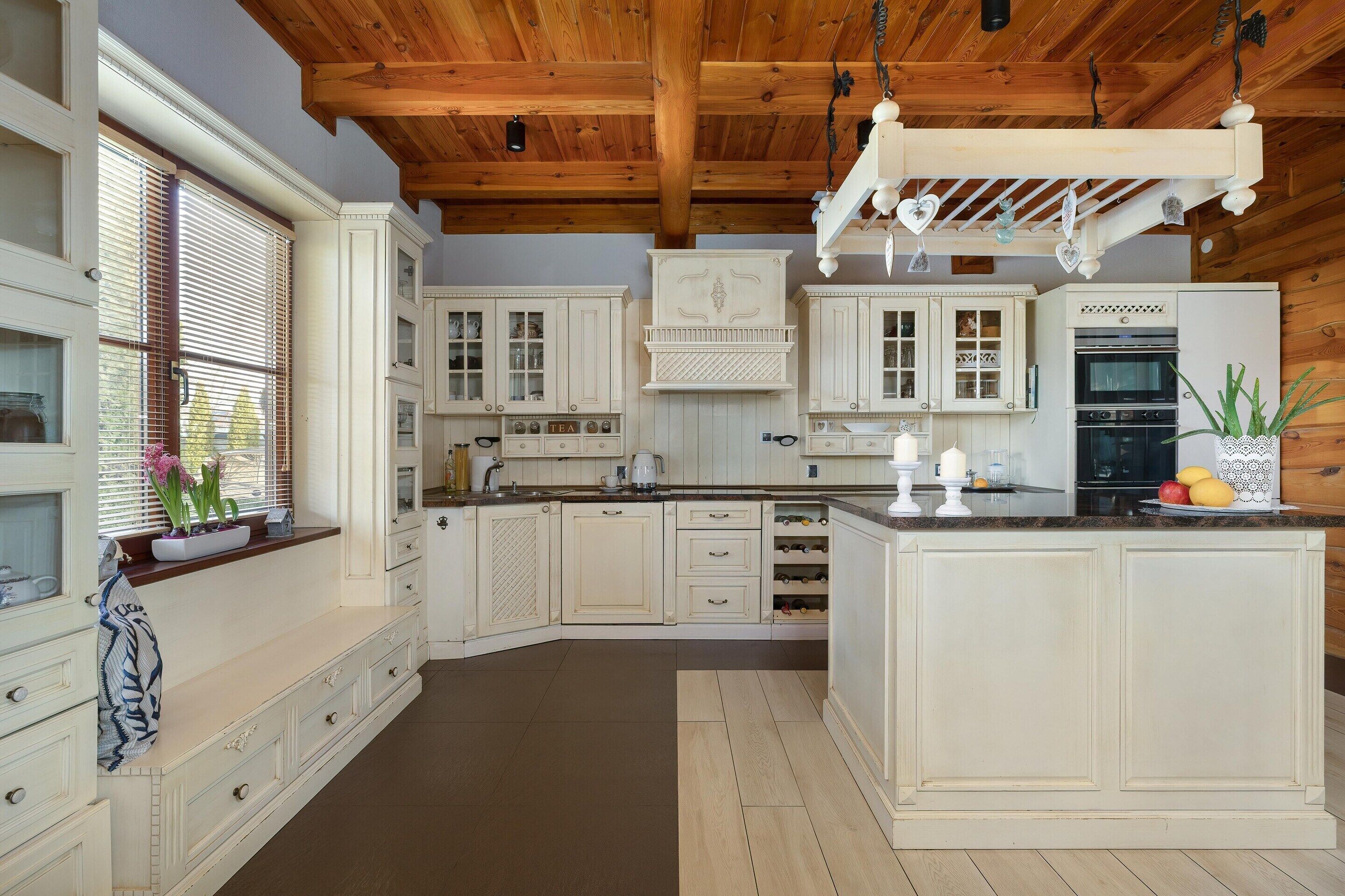 A kitchen with white cabinetry, a wooden ceiling, and a built-in oven.