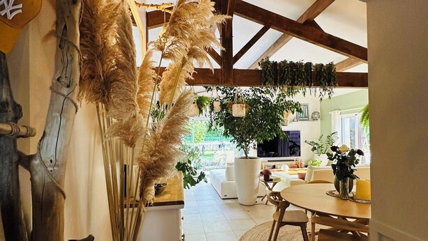 A spacious room with a high ceiling, a dining area with a round table, and a view of the outdoors. - Villa 5 minutes from the sea! Near Royan (Semussac)