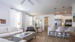 A modern living room with a sofa, coffee table, and chairs, a dining area with a table and chairs, and a kitchen with cabinets and appliances. - The Tanglewood, 3BR by Velvet Ditch Villas (Oxford)