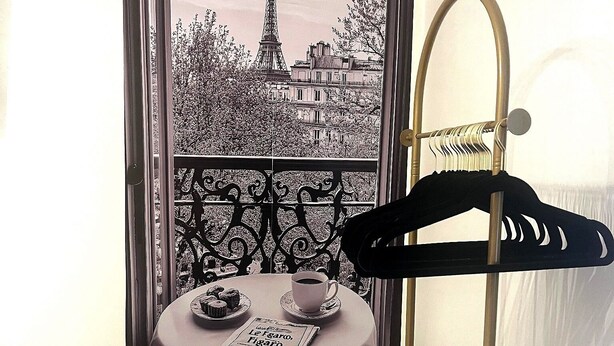 A room with a view of the Eiffel Tower, a table with a newspaper, a cup of coffee, and a coat rack. - 10 minutes from the beach-Apartment in charming Shallotte with AC (Shallotte)
