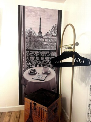 A room with a view of the Eiffel Tower, a table with a newspaper, a cup of coffee, and a coat rack. - 10 minutes from the beach-Apartment in charming Shallotte with AC (Shallotte)