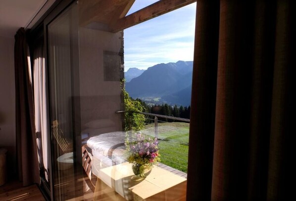 A balcony with a bed, a vase of flowers, and a mountain view. - B&B Fior (San Giovanni di Fassa)