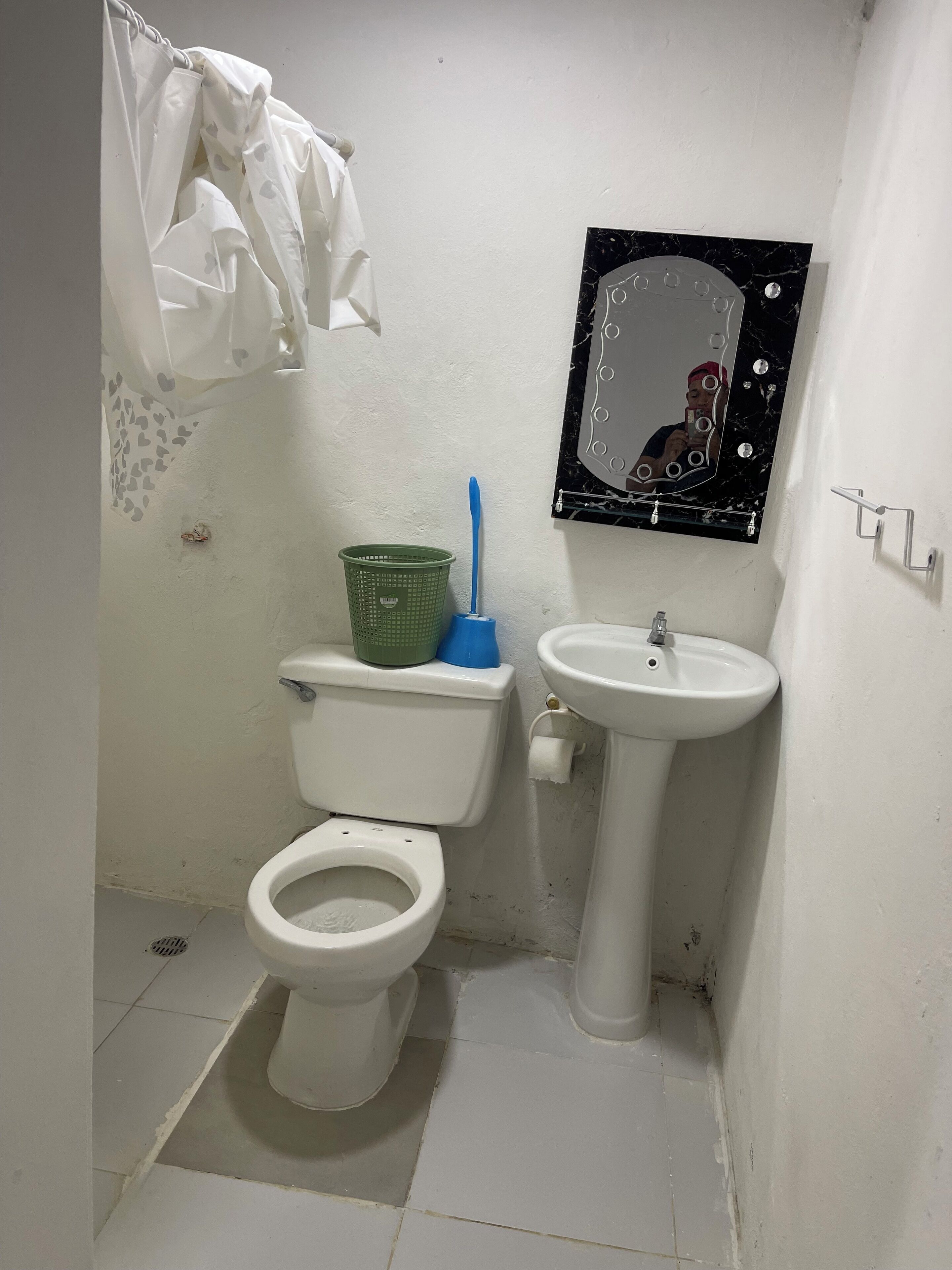Een kleine badkamer met toilet, wastafel en spiegel.