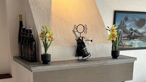 Ein moderner Kamin mit Kaminumbau, einem Gemälde und einem blauen Sessel.