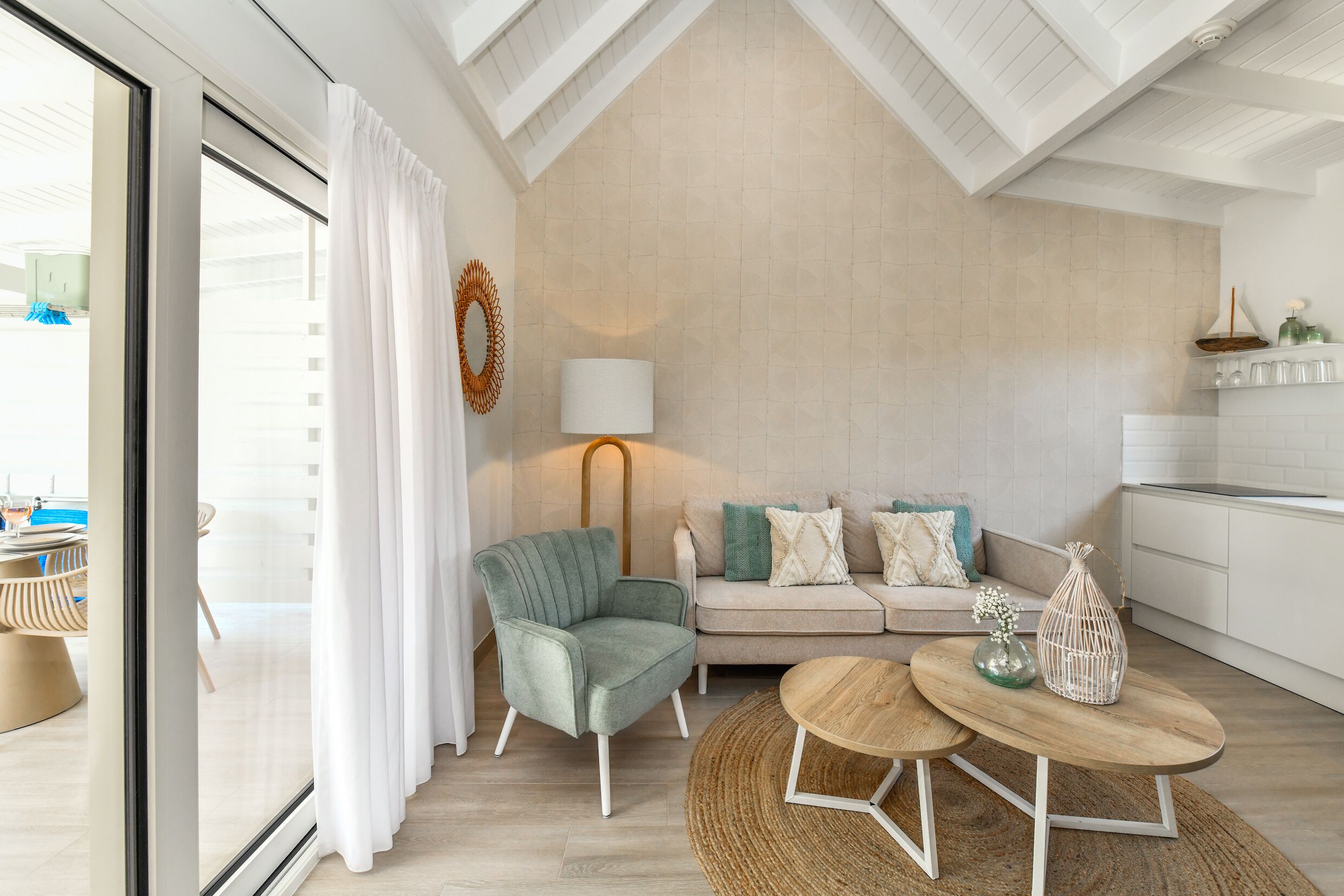 Een moderne woonkamer met een bank, fauteuil en een ronde houten tafel.