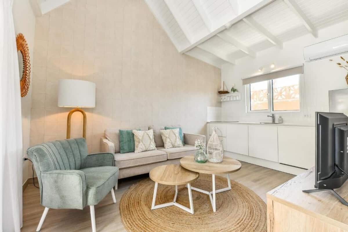 Departamento Confort, vista al jardín | Área de sala de estar