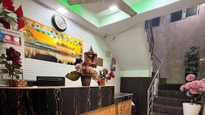 A reception desk with a clock, a fire extinguisher, and a staircase. - Hotel Park Avenue (Lucknow)