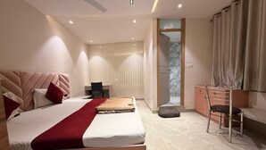 A modern hotel room with a large bed, a desk, a chair, and a bathroom visible through an open door. - Hotel Park Avenue (Lucknow)