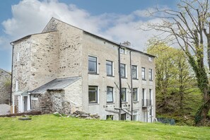 Un bâtiment en pierre doté de nombreuses fenêtres et d’un toit en pente.