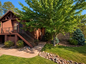 A two-story log cabin with a stone exterior, a covered porch, and a stone wall. - Escape the Arizona Heat + 2 King Suites + Bunk Room (Show Low)
