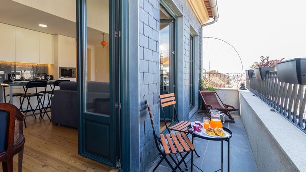 Een modern appartement met balkon, keuken en eethoek.