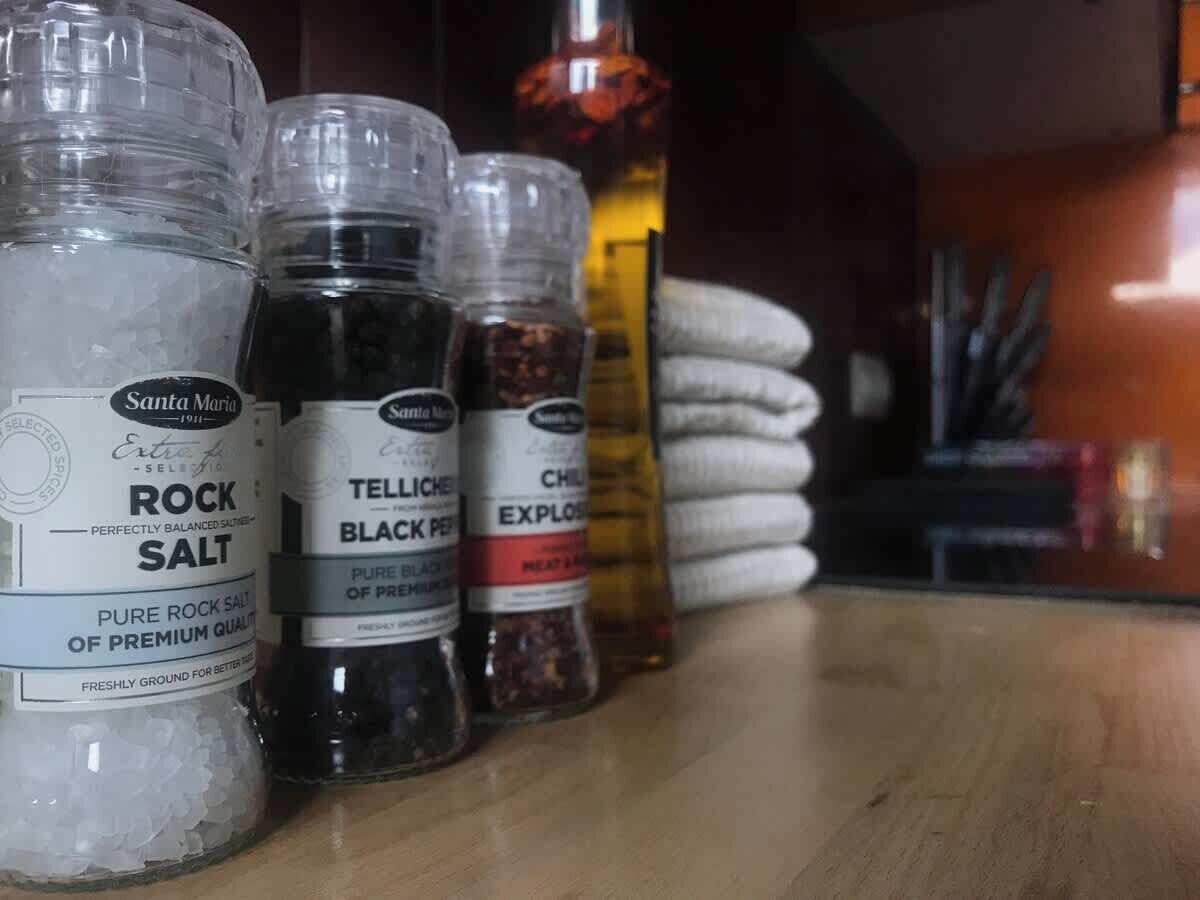 Variedad de saleros y pimenteros sobre una superficie de madera.