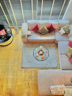 A modern living room with a sectional sofa, a round chair, and a decorative rug.