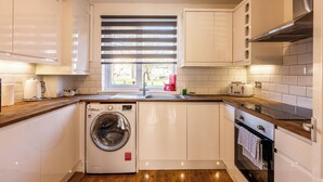 A compact kitchen with a washing machine, a toaster, and a sink. - Paisley with Parking & Balcony - Pass the Keys (Paisley)