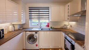 A compact kitchen with a washing machine, a toaster, and a sink. - Paisley with Parking & Balcony - Pass the Keys (Paisley)