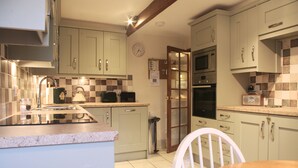 A kitchen with a microwave, oven, and a coffee maker on the countertop. - Country Hideaways | Turnsyke Barn | Newbiggin (Leyburn)