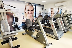 A gym with treadmills, weight machines, and a large mirror. - Loft em Ponta Negra com vista para o mar (Natal)