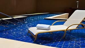 Une piscine sur le toit, avec deux chaises longues et une serviette.