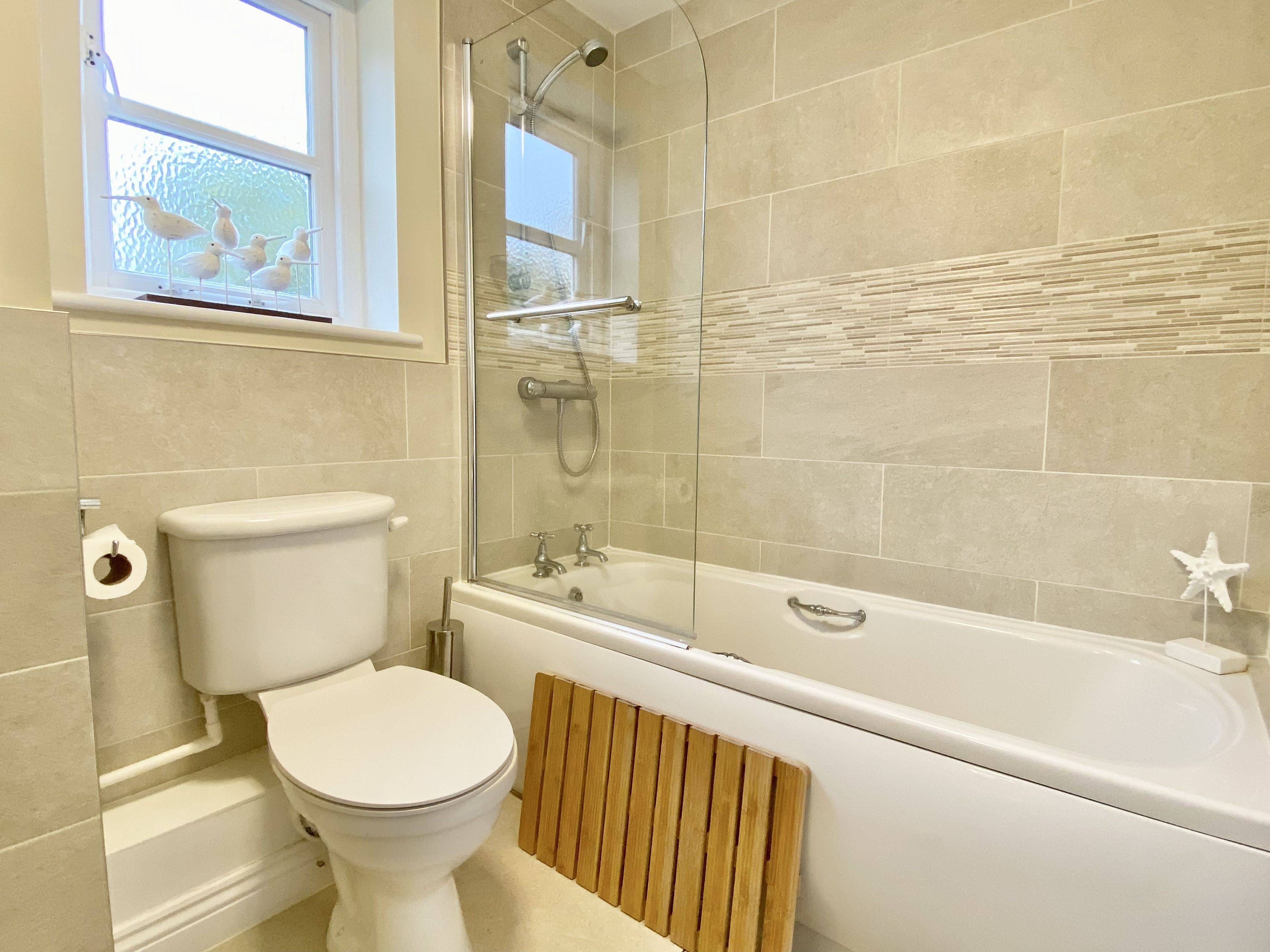 Une salle de bain équipée de toilettes, d’une baignoire et d’une douche.