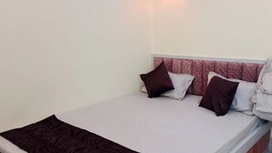 Een enkel bed met hoofdeinde, kussens en dekbed.