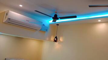 A room with a ceiling fan, an air conditioning unit, and a pendant light.