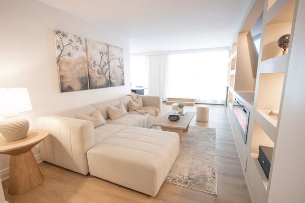 A modern living room with a sofa, coffee table, and artwork on the wall.