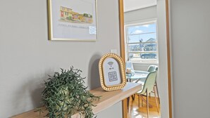 A framed artwork, a potted plant, and a Wi-Fi symbol on a shelf. - Walkable Downtown Sturgeon Bay - The Florist House (Sturgeon Bay)